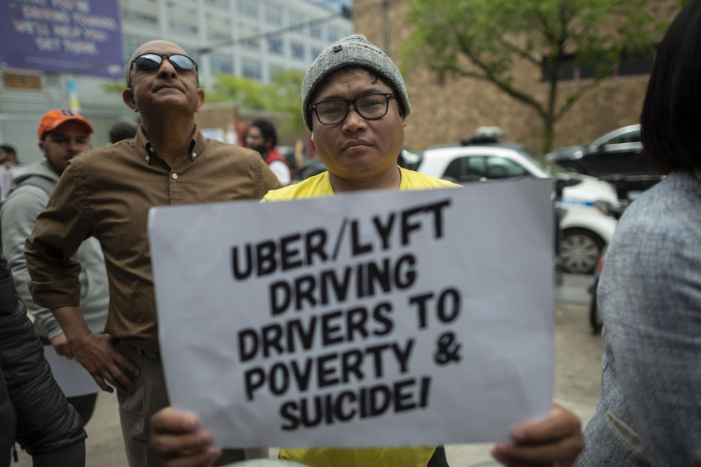 Tài xế Uber và Lyft biểu tình ở San Francisco hồi tháng 4/2019. Trong ảnh một người cầm tờ giấy in dòng chữ: 