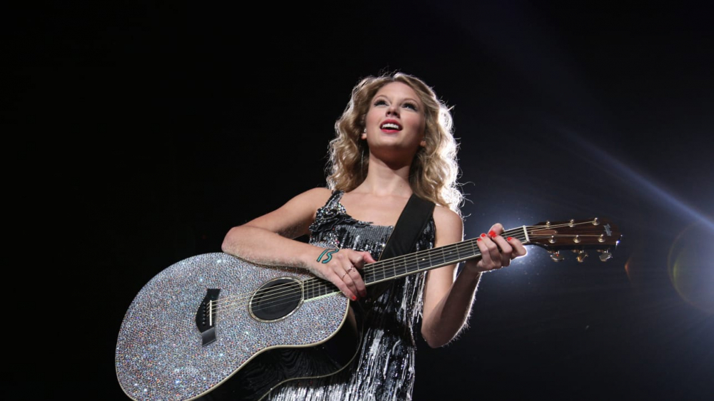 Nữ ca sĩ Taylor Swift biểu diễn với con số may mắn 13 trên tay.  