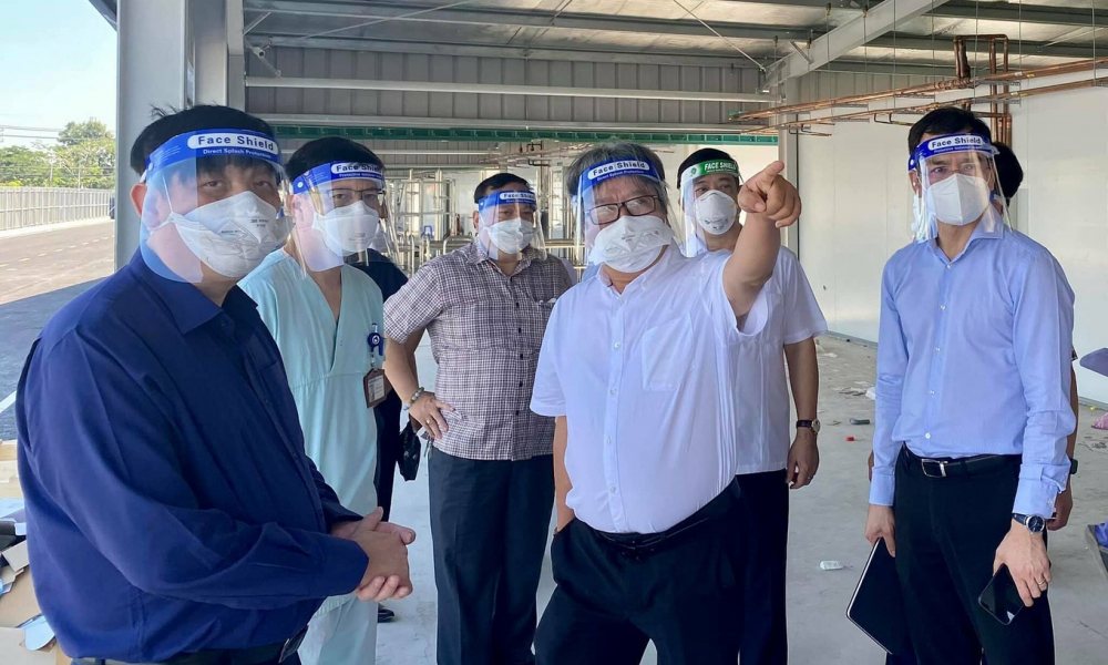 Giáo sư Trần Bình Giang (áo trắng) giới thiệu với Bộ trưởng Nguyễn Thanh Long (trái) về kế hoạch mở rộng quy mô Trung tâm ICU của Bệnh viện Việt Đức đặt tại Bệnh viện Dã chiến số 13. Ảnh: Vũ Mạnh Cường.