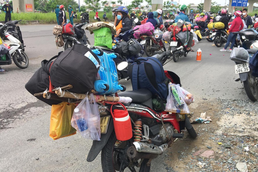 Khi TPHCM tiếp tục kéo dài áp dụng giãn cách xã hội theo Chỉ thị 16, những ngày gần đây, nhiều người dân từ Thành phố lại tìm đường về quê bằng xe máy.
