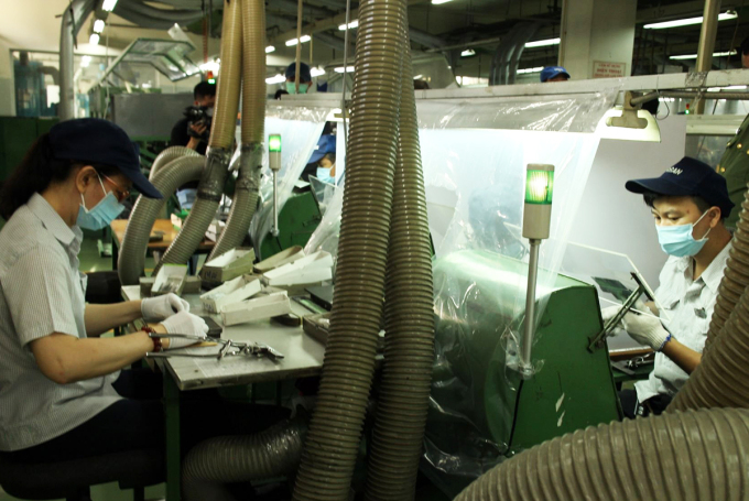 Nhà máy Kim may Organ ở Khu chế xuất Tân Thuận lắp tấm chắn ở chuyền sản xuất. Ảnh: An Phương