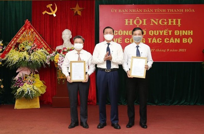 Ông Đỗ Minh Tuấn, Chủ tịch UBND tỉnh Thanh Hóa trao quyết định cho ông Hoàng Văn Thị và Bùi Văn Dũng (Ảnh: Trần Lê).