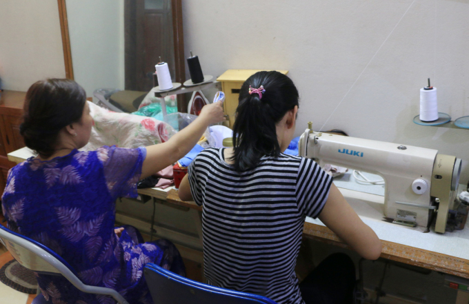 Chị Nguyệt (phải) may khẩu trang kiếm thu nhập trong thời gian ở nhà tạm lánh của Hội liên hiệp Phụ nữ Việt Nam hồi tháng 10. Ảnh: Nhật Linh