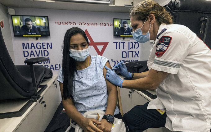 Một bác sĩ tại dịch vụ y tế Magen David Adom tiêm liều vaccine Covid-19 thứ ba cho một phụ nữ ở Tel Aviv, Israel, ngày 14/8. Ảnh: AP