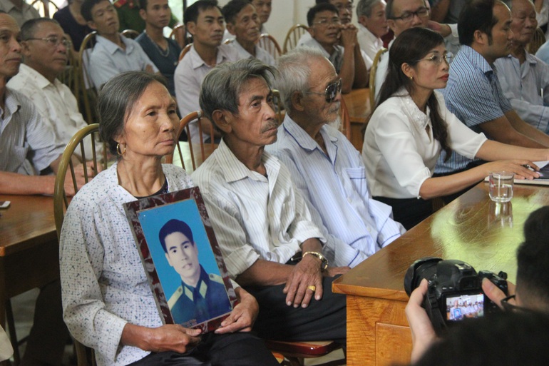 Hình ảnh vợ ông Trần Trung Thám ôm di ảnh của chồng ngồi cạnh ông Trần Ngọc Chinh (giữa) và ông Khổng Văn Đệ tại buổi cải chính công khai hồi tháng 10/2019 (Ảnh: Nguyễn Trường).