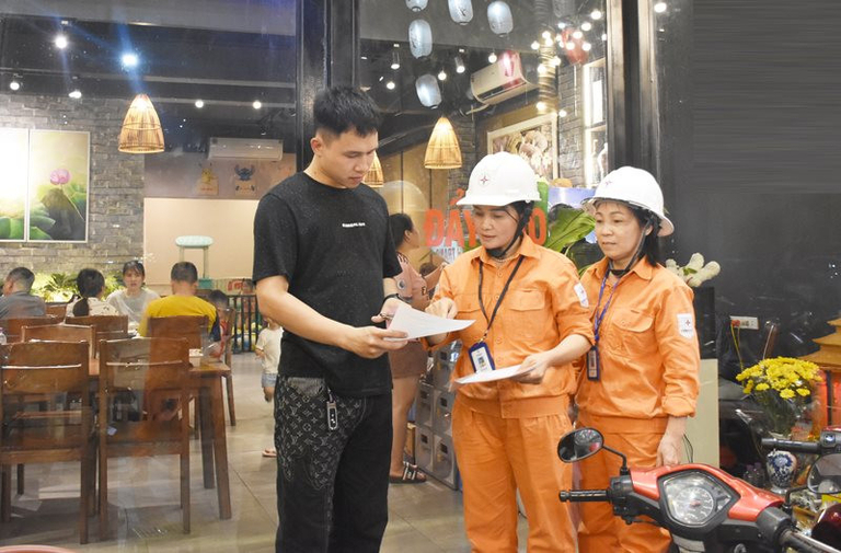 Nhân viên Tổng công ty Điện lực thành phố Hà Nội hướng dẫn người dân sử dụng điện tiết kiệm, an toàn, hiệu quả. Ảnh: Việt Anh