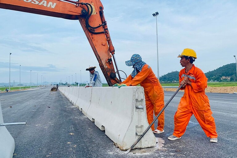 Các công nhân đang tiến hành lắp dải phân cách trên cao tốc Nghi Sơn - Diễn Châu. Ảnh: ĐẮC LAM