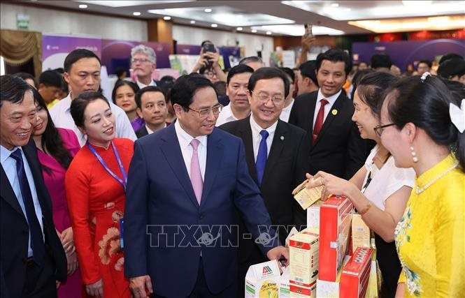 Thủ tướng Phạm Minh Chính thăm gian hàng trưng bày sản phẩm đổi mới sáng tạo - Ảnh: TTXVN