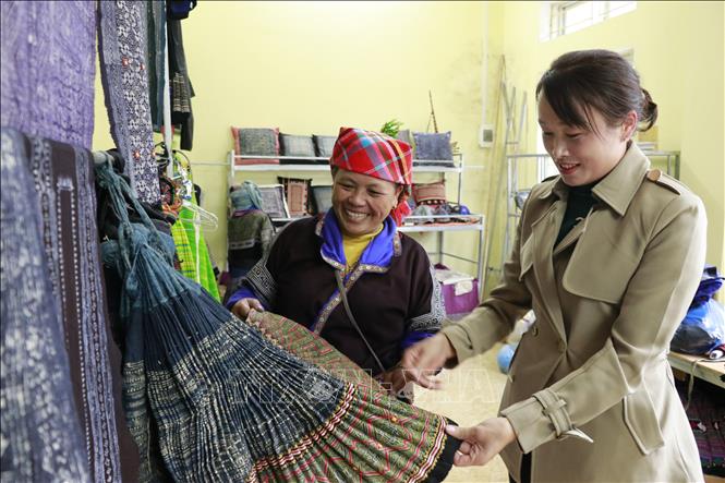 Chị Lý Thị Ninh, tổ hợp tác Thổ cẩm xã Chế Cu Nha, huyện Mù Cang Chải, giới thiệu sản phẩm cho du khách. Ảnh: Tuấn Anh/TTXVN