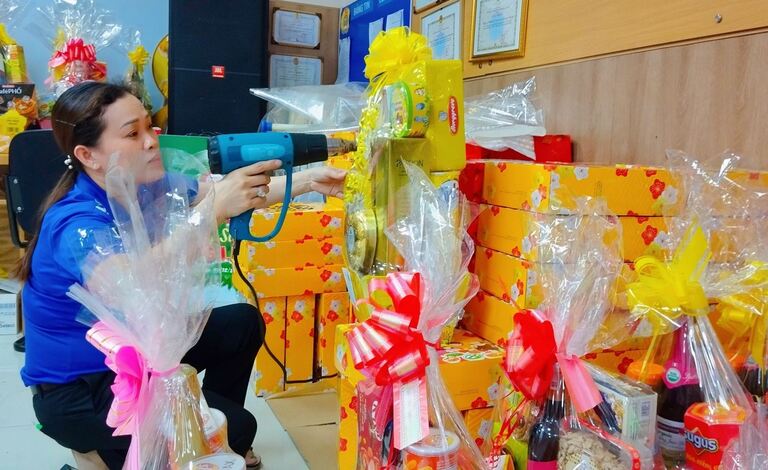 Các nhân viên gói quà Tết liên tục khi nhu cầu mua giỏ quà Tết bình dân tăng cao tại các siêu thị ở TP Hồ Chí Minh.