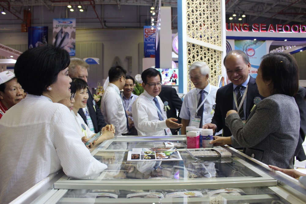 Ông Dương Nghĩa Quốc (giữa), Chủ tịch Hiệp hội Cá tra Việt Nam trao đổi với các đại biểu tại Hội chợ
