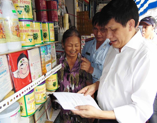 GS-TS Nguyễn Thanh Long kiểm tra chứng từ của một hộ kinh doanh hương liệu, màu thực phẩm trong chợ Kim Biên. Ảnh: TRẦN NGỌC