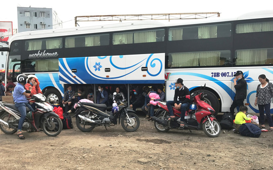 Hành khách ngồi vật vạ chờ xe xuất bến tại bãi xe ở đường Đinh Bộ Lĩnh Ảnh: Gia Minh