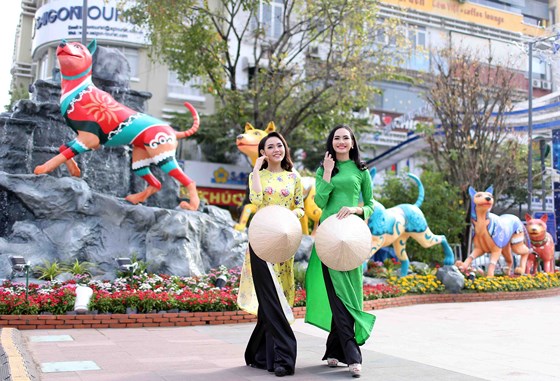 Người mẫu Trần Dương và Hoài Nhi trước hình tượng đàn chó Phú Quốc ở Đường hoa Nguyễn Huệ sáng nay.