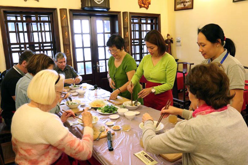 Du khách quốc tế thưởng thức ẩm thực truyền thống VN tại gian bếp của nghệ nhân Ánh Tuyết (phố Mã Mây, quận Hoàn Kiếm) Ảnh: Hồng Ánh
