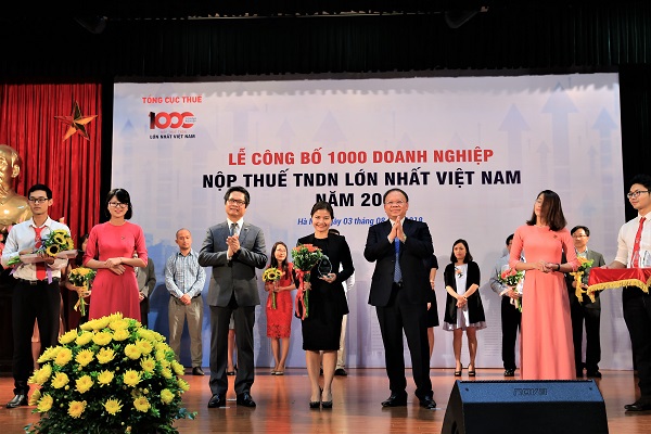 Ông Bùi Văn Nam, Tổng cục trưởng Tổng cục Thuế và ông Vũ Tiến Lộc, Chủ tịch Phòng thương mại và công nghiệp Việt nam (VCCI) trao hoa và kỷ niệm chương cho đại diện công ty TNHH Nestlé Việt Nam tại lễ công bố.
