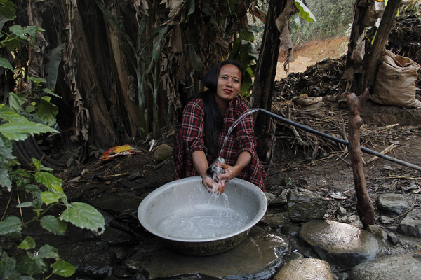 Sharada Bogati đến từ Bidur (Nepal) rửa cốc bên cạnh nhà cô. Không giống như nhiều khu phố ở Bidur, nhiều gia đình sống cùng khu với cô có đủ nước để sử dụng hàng ngày và thậm chí trồng rau. Ảnh: Bhrikuti Rai