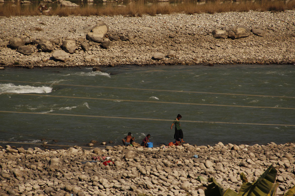 Phụ nữ và trẻ em giặt quần áo trên bờ sông Trisuli gần thị trấn Bidur. Ảnh: Bhrikuti Rai