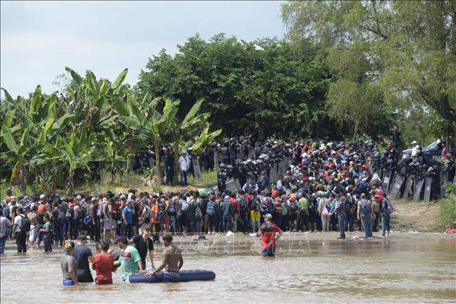 Người di cư băng qua sông Suchiate từ Ciudad Tecun Uman (Guatemala) để tới Ciudad Hidalgo (Mexico) trong hành trình đến Mỹ, ngày 29/10/2018. Ảnh: AFP/TTXVN  