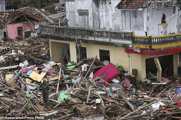 Binh sĩ Indonesia kiểm tra tình hình thiệt hại tại một ngôi làng bị sóng thần tàn phá, ngày 25/12. Ảnh: AP