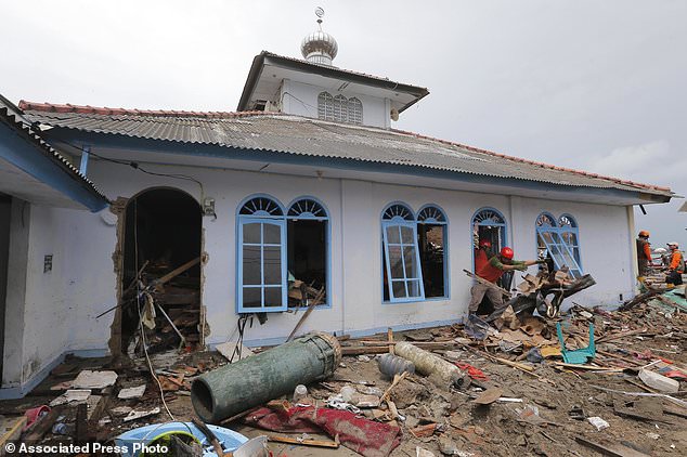 Người dân dọn dẹp một thánh đường sau thảm họa sóng thần. Ảnh: AP chụp ngày 25/12