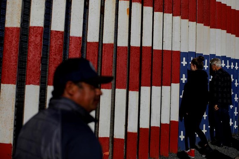 Người dân nhìn qua hàng rào biên giới Mỹ - Mexico bên phía Tijuana, Mexico.