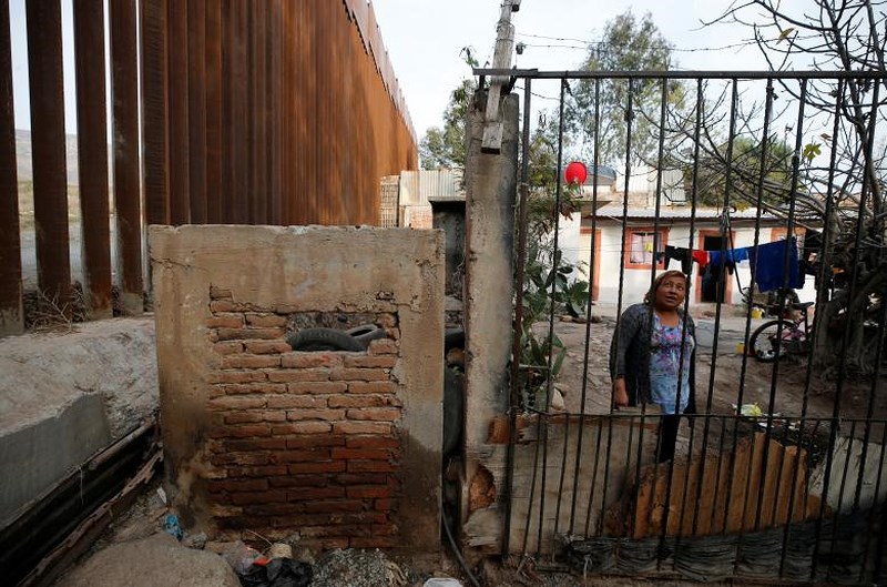 Một người phụ nữ Mexico sống ngay cạnh hàng rào biên giới Mỹ - Mexico.