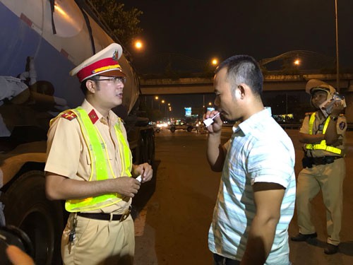 Lực lượng chức năng kiểm tra nồng độ cồn tài xế xe tải ở khu vực vòng xoay An Lạc (quận Bình Tân) vào tối 15-1. Ảnh: Gia Minh