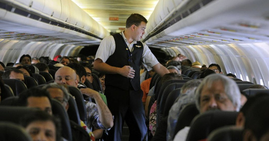 Một tiếp viên hàng không của hãng Frontier Airlines nhắc nhở hành khách trước giờ cất cánh Ảnh: AP