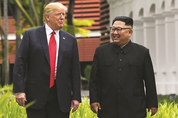 Tổng thống Donald Trump và Chủ tịch Kim Jong-un đi dạo trong khuôn viênkhách sạn Capella trưa 12/6/2018. ( Ảnh: AFP).