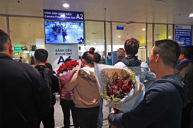 Những bó hoa tươi thắm chờ đón người thân trở về đón Tết sau những năm tháng làm ăn ở nước ngoài tại nhà ga quốc tế, sân bay Nội Bài.  