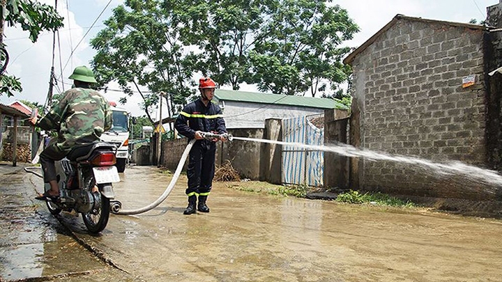 Cảnh sát phòng cháy, chữa cháy TP Hà Nội phun nước rửa đường làng tại xã Nam Phương Tiến, huyện Chương Mỹ. Ảnh: MẠNH THẮNG  