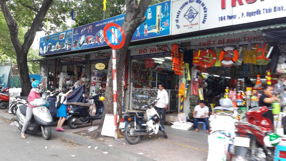 Tại trung tâm dân sinh trên đường Yersin, các cửa hàng vẫn bày bán tràn lan và lấn chiếm cả vỉa hè cho khách đậu xe (Ảnh: Hoàng Uyên)