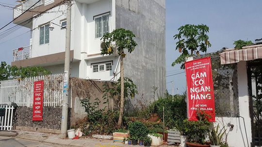 Người dân tại khu dân cư Nam Sài Gòn Riverside treo băng-rôn phản đối chủ đầu tư cũng như cảnh báo những người có ý định mua đất tại khu vực này Ảnh: SƠN NHUNG