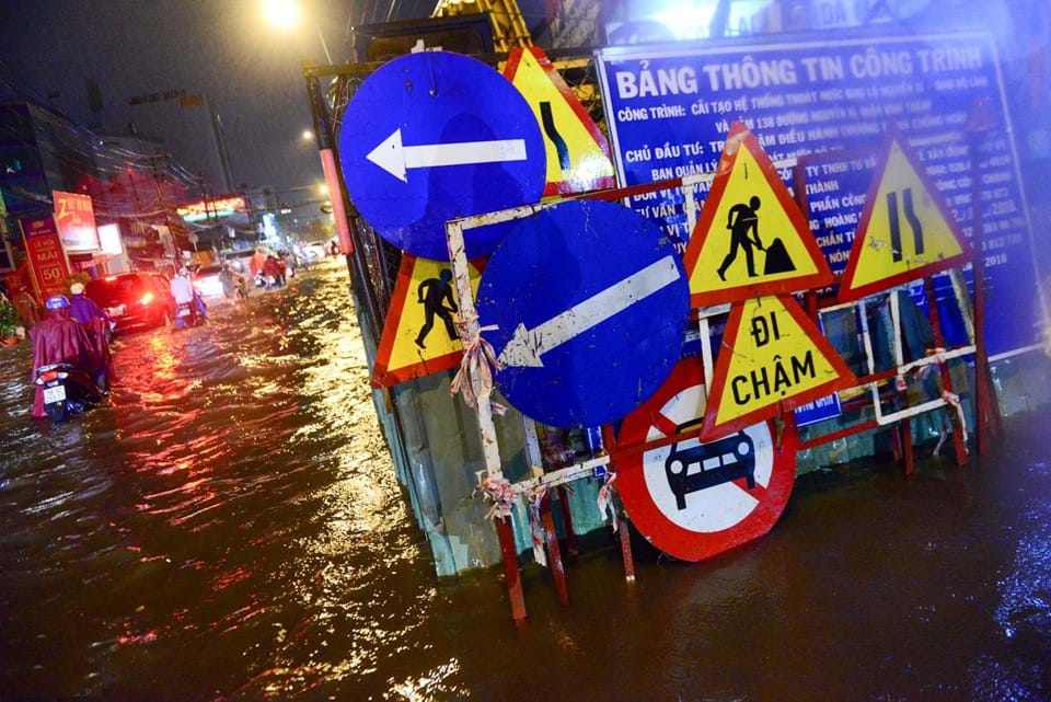 Công trình cải tạo hệ thống thoát nước đường Nguyễn Xí ngập trong nước. Ảnh: Tùng Tin    