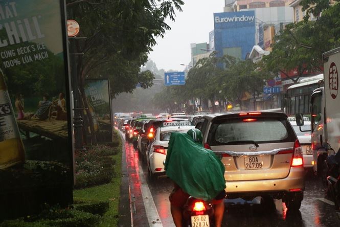 Các phương tiện xếp hàng dài trên đường Trường Sơn, Trần Quốc Hoàn hướng ra vòng xoay Lăng Cha Cả. Hàng nghìn người dân phải chôn chân dưới mưa.