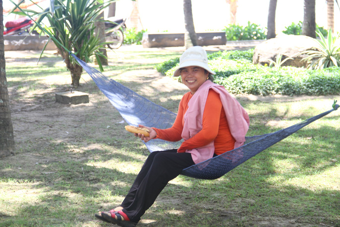 Người dân mắc võng để nghỉ dưới những tán dừa nằm gần công viên Biển Đông