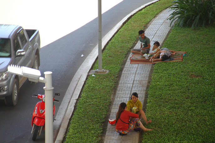 Người dân nghỉ chân trên các thảm cỏ phía dưới chân nút giao thông Ngã Ba Huế