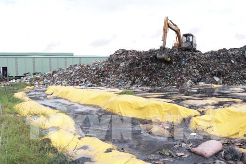 Hàng nghìn tấn rác được tập kết tạm trước cửa nhà máy để chờ xử lý gây ô nhiễm nghiêm trọng, ảnh hưởng đến đời sống và sức khỏe của người dân. Ảnh: Huỳnh Phúc Hậu - TTXVN    