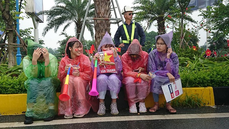 Bất chấp mưa lớn, những cô gái này người ướt sũng nhưng vẫn vui cười, chờ đón để gặp các chàng trai Olympic Việt Nam. (Ảnh: Vietnamnet)    