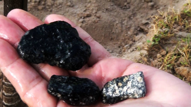 Những viên đá đen mà người dân vừa đào được.