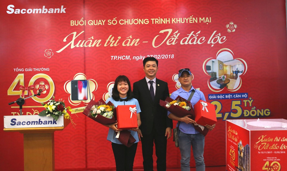 Ông Nguyễn Minh Tâm, Phó Tổng Giám đốc Sacombank (giữa) trao giải bốc thăm may mắn cho các đại diện khách hàng tham dự buổi quay số.