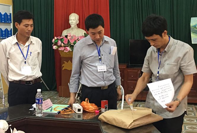 Cán bộ làm thi tại điểm thi THCS Ngũ Hiệp (Thanh Trì) đang dán, niêm phong bài thi trước sự chứng kiến của thư ký, thanh tra. Ảnh: Nguyễn Hà.