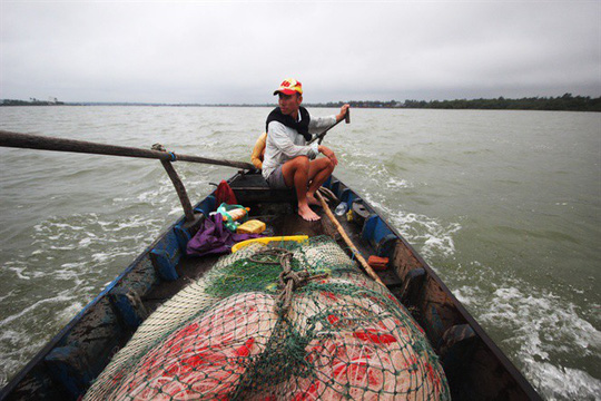Anh Trần Công Quang bắt đầu một ngày thả lưới bắt cá trên cửa sông An Hòa