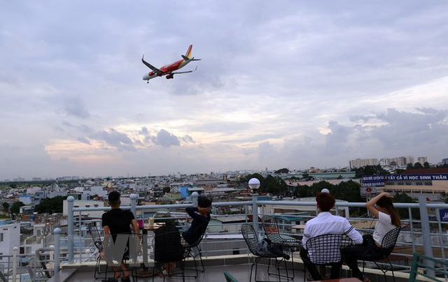 Những năm gần đây, người dân tại Thành phố Hồ Chí Minh có một sở thích mới là vừa uống càphê vừa ngắm máy bay bay ngang đầu tại những quán sân thượng gần sân bay Tân Sơn Nhất. (Ảnh: Huy Hùng/TTXVN)