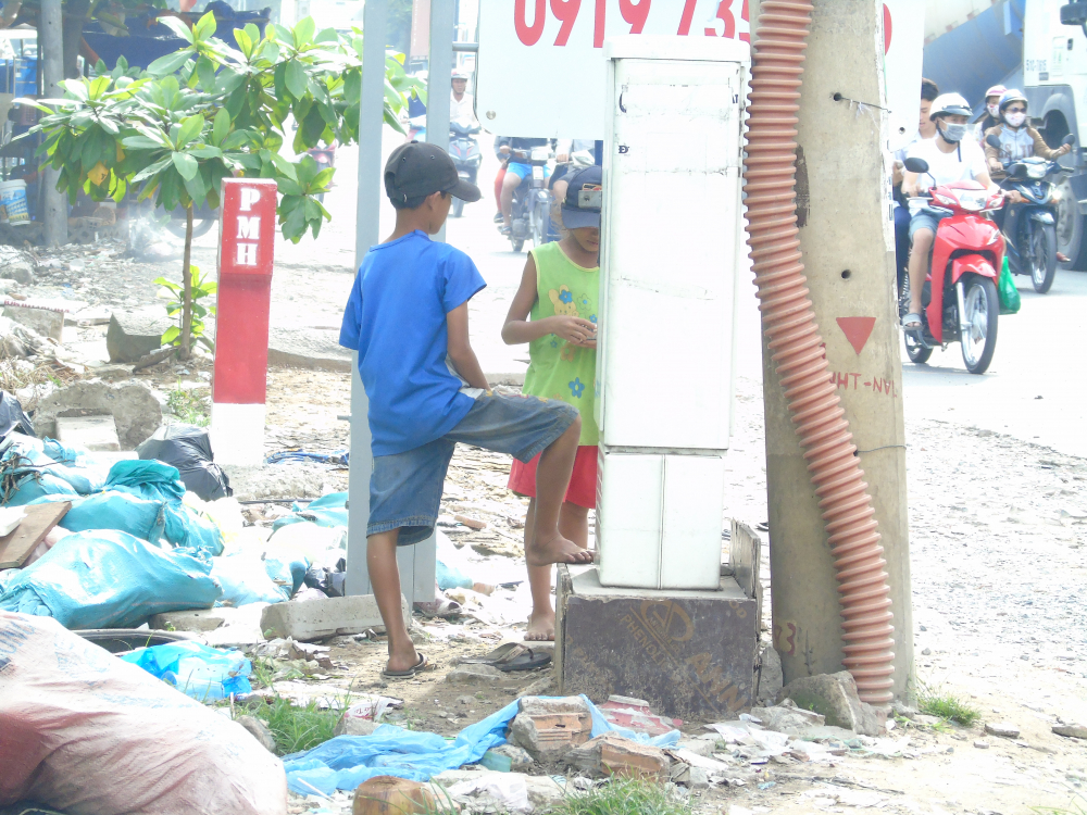 Theo người dân gần đây cho biết, các em thường đứng xin tiền dọc theo các cây đèn giao thông trên đường Nguyễn Văn Linh (Q.7). 