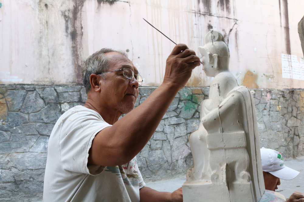 Ông Mai Văn Thuấn vẫn đang say sưa trét thạch cao để tạo ra một bức tượng hoàn chỉnh.