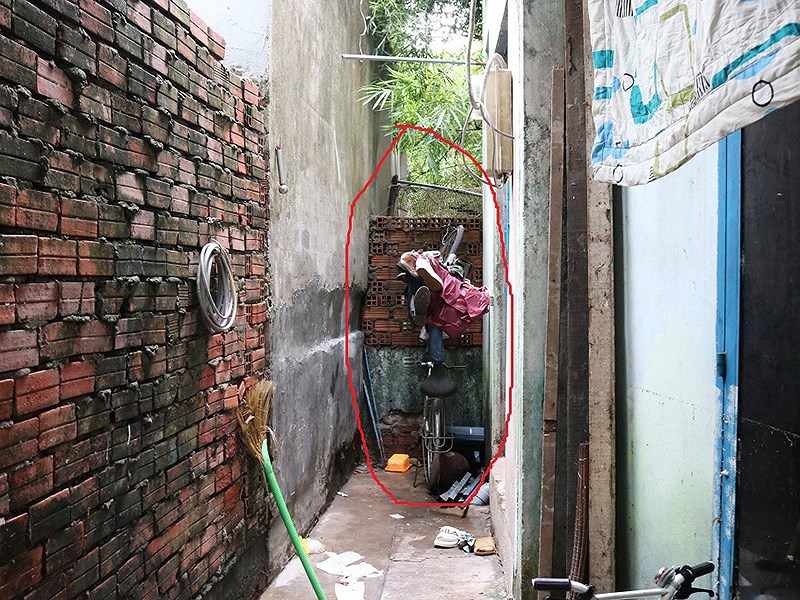 Bức tường được một hộ dân ở phường Phước Long B xây lên, ngăn dòng nước thoát qua hố ga nằm ngay vách bức tường. Ảnh: THANH TUYỀN
