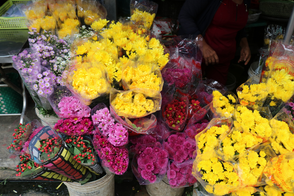 Ngoài ra, các gian hàng hoa cũng tấp nập người mua. Hoa cúc vàng là loại hoa được đông đảo mọi người lựa chọn. (Ảnh: Huy Hoàng)