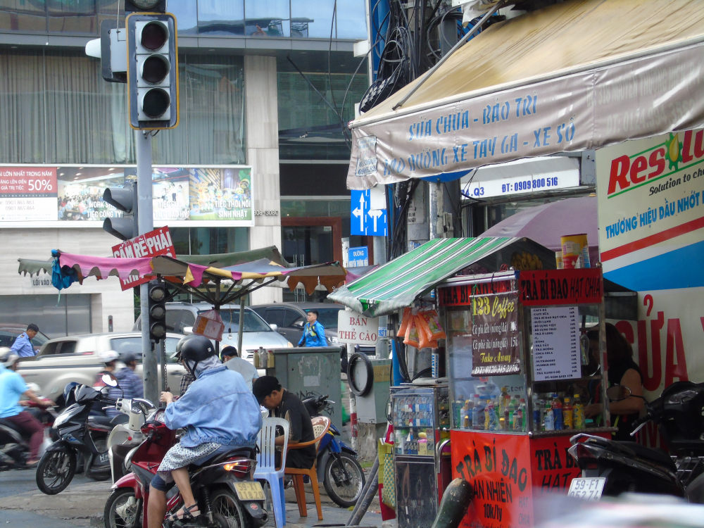 Khúc cua đường Nguyễn Thượng Hiện (Q.3) có hai biển báo giao thông bị che lấp bởi mái hiên của những hàng kinh doanh. 